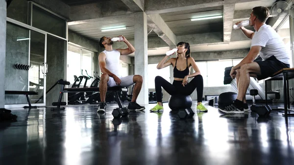 Group of young sporty people resting after working out and drink — Stock Photo, Image