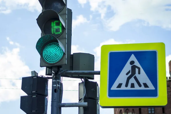 traffic light with green on blue sky background pedestrian crossing sign