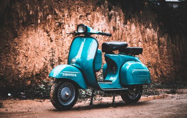 Kirli duvara karşı klasik açık mavimsi scooter motoru