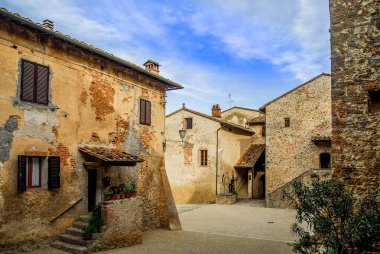 Abbadia a Isola (Siena), İtalya - 05: 05: 13 2006: Tuscany yakınlarındaki Monteriggioni kentinin önüne ortaçağ tahkim edilmiş bir manastırın (İtalyanca adı) yanına inşa edilmiş eski bir köy