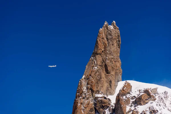 飛行機は晴れた日に青い空の高い高度で山の上を飛んでいます 手前のロッキー山脈 — ストック写真