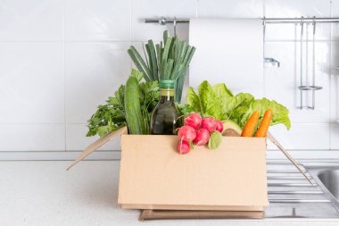 İçinde meyve ve sebzeler olan bağış kutusu. Yemek konseptini paylaşmak. Yemek dağıtım gönüllüsü yiyecek topluyor. Coronavirus pandemik yardım. Ön görünüm