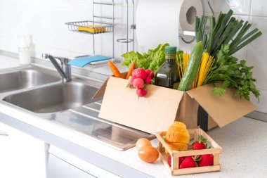 İçinde meyve ve sebzeler olan bağış kutusu. Yemek konseptini paylaşmak. Yemek dağıtım gönüllüsü yiyecek topluyor. Coronavirus pandemik yardım. Ön görünüm