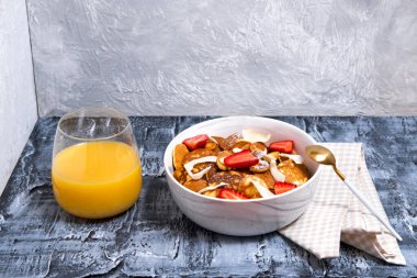 Çilekli küçük krep gevreği ve beton zeminde portakal suyu bardağı. Moda kahvaltı, Amerikan yemeği, mesaj için yer.