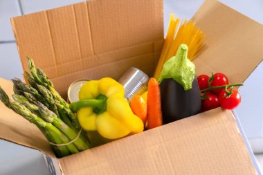 İçinde meyve ve sebzeler olan bağış kutusu. Yemek konseptini paylaşmak. Yemek teslimatı. Coronavirus salgını yardımı