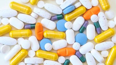 Beyaz arka planda çok renkli haplar. İlaç, ilaç tabletleri. Eczane konsepti. Sağlık hizmeti, koronavirüsü durdurun. Makro fotoğraf, düz görünüm