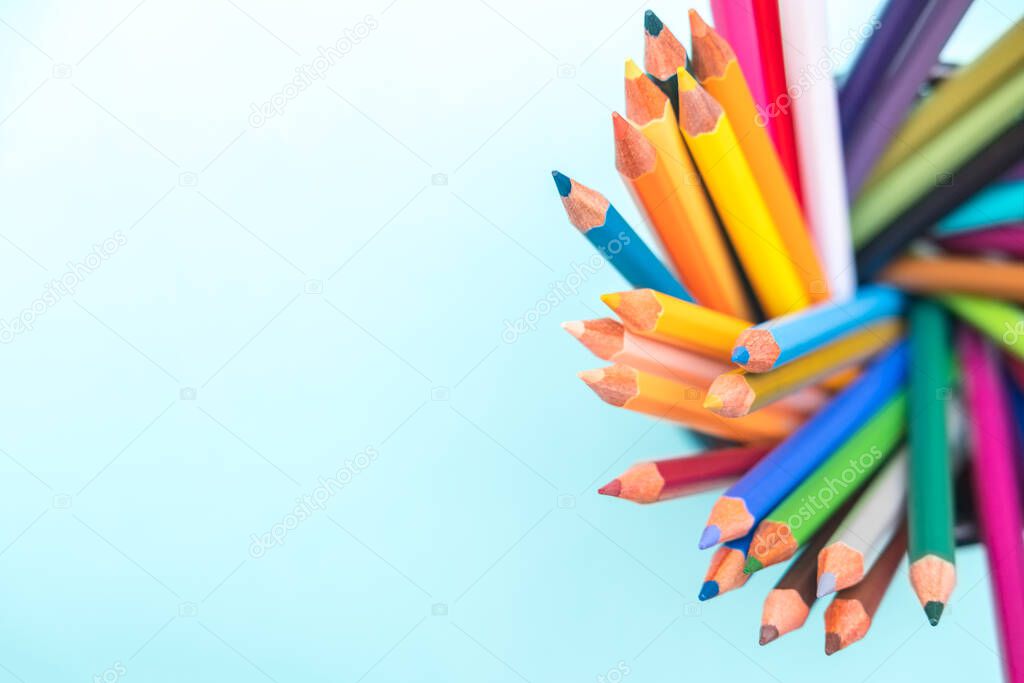 Palette kit of multi colored pencils on green background. Space for text, back to school. Sketching and drawing hobby. Stationery supply store