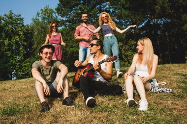 Bir grup arkadaş yaz parkında eğleniyor.