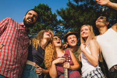 Bir grup arkadaş yaz parkında eğleniyor.