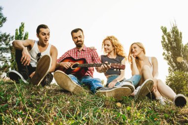 Bir grup arkadaş yaz parkında eğleniyor.