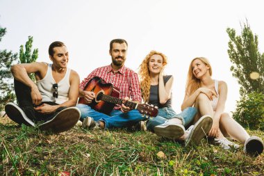 Bir grup arkadaş yaz parkında eğleniyor.