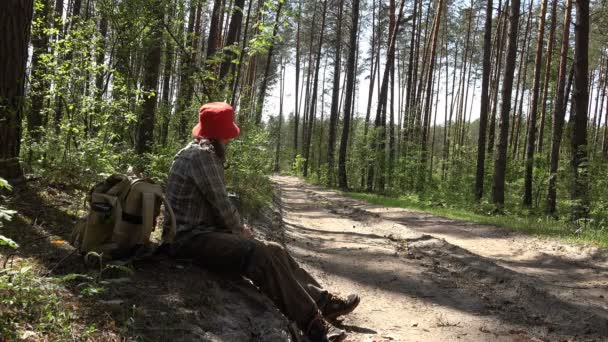 Ekologicky šetrné prostředky, zralý muž visí na slunné straně solární drží, v lese letní cesta