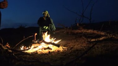 Bir sosis yanıyor olgun adam konuşan zemin karşı dağlarda gece fry. Aktif insanlar Traveler