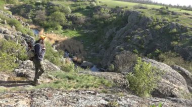 Olgun turist adam ihtiyatlı bir uçurumun kenarına dağ manzarası, gorge erken yaz sabahı yaklaşıyor.
