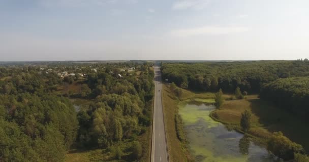Drone écrasé de grande hauteur sur fond d'autoroute et de lac forestier 