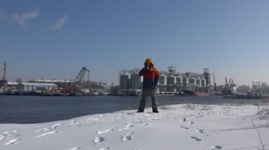 Erkek işçi Nehri'nin bir kış tahıl ambarları limanda endüstriyel bir görünümünü arka plan üzerinde yürüyor