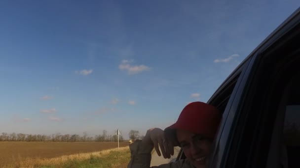 小女孩的旅行伙伴和旅行者 搭便车 微笑着 欢快地尖叫着 然后在车后座上向窗外挥挥手 — 图库视频影像