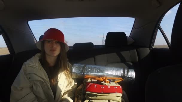 若い女の子の旅行の仲間と旅行者 車の後部座席でヒッチハイクの笑顔の乗り物 近くの観光バックパックスタンド — ストック動画