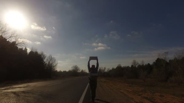 Dojrzały Mężczyzna Autostopowicz Turystycznych Spacerów Wzdłuż Drogi Plecakiem Ramionach Podnoszenia — Wideo stockowe