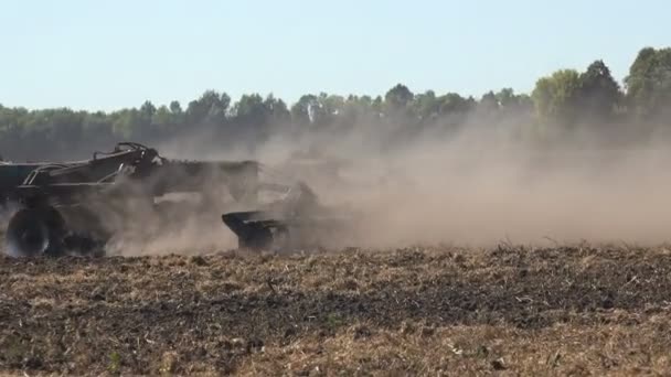 拖拉机在播种机上播种干枯的黑土 在大片农田上播种小麦 冒出浓烟 — 图库视频影像