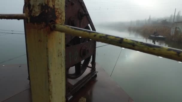 朝早く霧と露が鉄のメカニズムに落ちる川の上の金属浮遊橋 — ストック動画