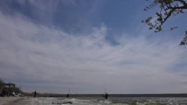 Ufukta. Üç sporcu, uçurtma sörfü olarak da bilinen aktif Kiteboard sporuna hazırlanıyor. Wakeboard, snowboard, rüzgar sörfü, yamaç paraşütü, kaykay ve bir ekstrem spora yelken açmak.