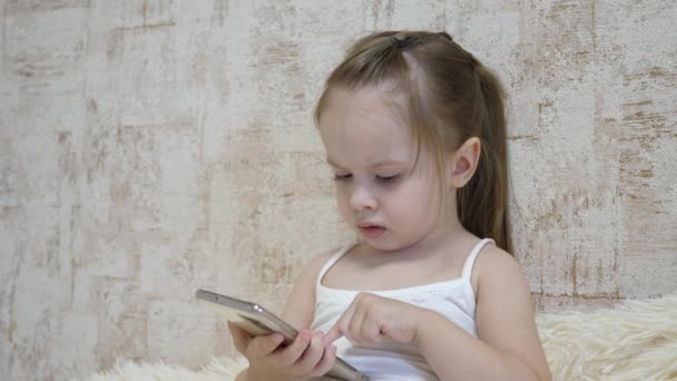 Małe dziecko rozmawia przez telefon przez połączenie wideo. Dzieciak komunikuje się zdalnie przez aplikację mobilną. Edukacja przedszkolna z wykorzystaniem Internetu. Zbliżenie — Wideo stockowe