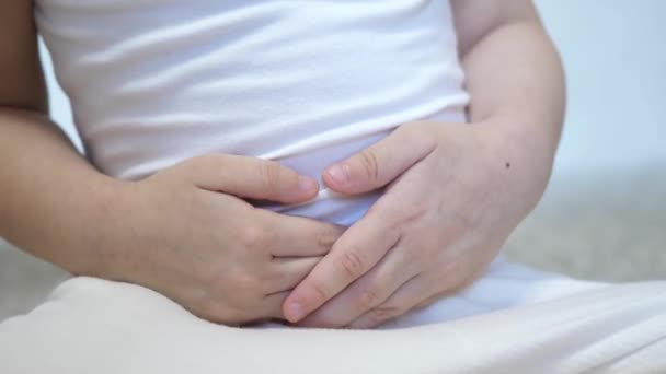 Een klein kind heeft buikpijn. Hij houdt zijn handen op zijn buik. Vergiftiging van het spijsverteringskanaal. Aanhangsel — Stockvideo