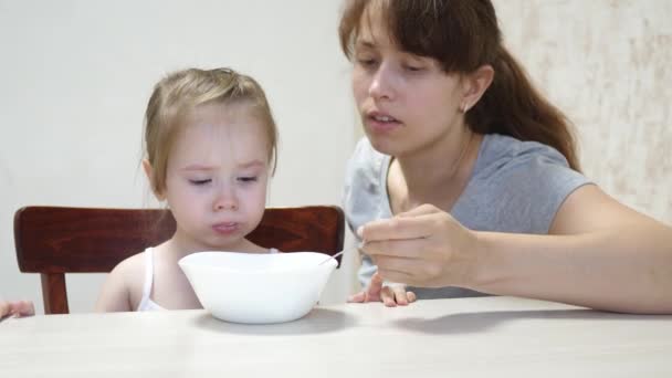 Máma krmí dítě lžící. Mléčná snídaně pro zdravé dítě. Mateřská a mateřská. Týmová práce — Stock video