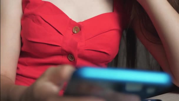 En ung flicka håller en smartphone i handen och fjärrbesöker butiken genom ansökan — Stockvideo