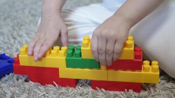 Barnet samlar på en leksak. Kid konstruktör spel för att förbättra motoriska färdigheter, hjärnans utveckling och tänkande. — Stockvideo