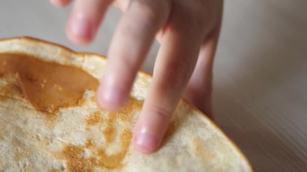 Die Hand eines kleinen Kindes nimmt einen Teller mit Pfannkuchen. Gesunde Ernährung für Kinder. Frühstückskind. Nahaufnahme — Stockvideo