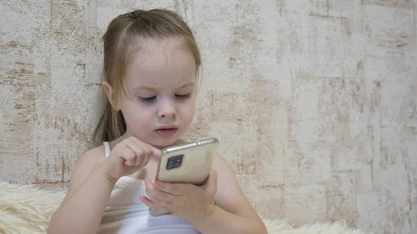 Маленький ребенок разговаривает по телефону по видеосвязи. Ребенок общается удаленно через мобильное приложение. Дошкольное образование с использованием Интернета. Крупный план — стоковое фото