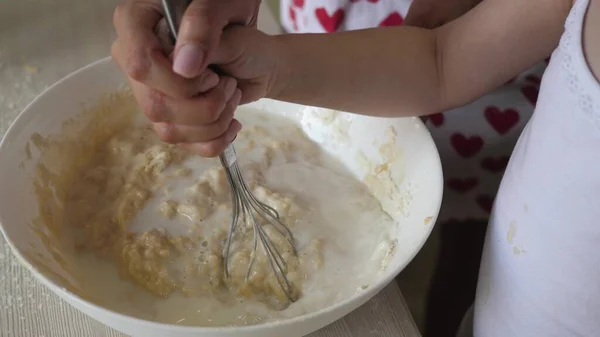 Anne bir çocuğa hamur pişirmeyi öğretiyor. Anne ve çocuk çırpılmış bir çırpıda bir parça un ve sütle dövülmüş. Evde ailenle yemek pişirmek. Takım çalışması. — Stok fotoğraf