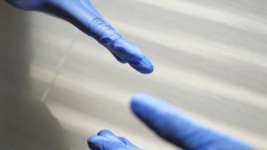 Sağlık çalışanları bir anlaşma üzerinde anlaştı. Mavi eldivenli doktorların el sıkışması. İş tıbbı. Takım çalışması. Sağlık çalışanları bir anlaşma üzerinde anlaştı. Salgın. Covid-19. Yakın plan.