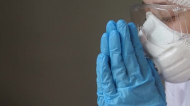 Sağlık, ilaç ve salgın konsepti - virüs hastalıklarından korunmak için yüz koruyucu maske takan üzgün genç kadın doktor veya hemşire. Kovid-19. Salgın. Yakın plan.