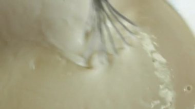 El, un ve süt yumurtalarından bir hamuru çırpıcıyla çırpar. Un ürünleri. Yemek pişirmek. Yakın plan.