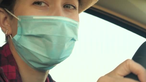 Ung kvinna kör bil bär medicinsk mask för att förhindra spridning COVID-19. Köra hona med ansiktsmask i bilen för att skydda mot virusinfluensa — Stockvideo
