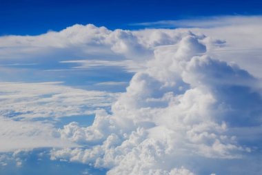 Bulutlu mavi gökyüzünün havadan görüntüsü. Uçak penceresinden bulutlar ve gökyüzü