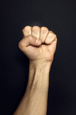 Siyah arka planda erkek yumruğu. Saldırganlık, erkeklik, meydan okuma konsepti..