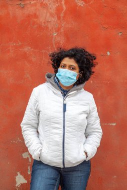 Karantina sırasında koruyucu maske ve eldiven takan bir kadın.