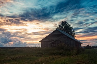 Eski bir ahır yaz alanların bir yaz akşamları Kuzey Finlandiya duruyor. Gece sonbahar yaklaşıyor gibi daha koyu alıyorsanız.