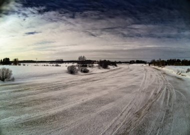 Batan güneşin dramatik desenler üzerinde gökyüzü buzlu Nehri Kuzey Finlandiya oluşturur.