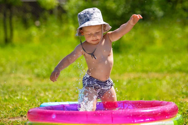 Güzel gülümseyen bir çocuk portresi. Bir çocuk bir şişme havuzda banyoları