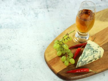 Üzümle servis edilen bir parça mavi peynir.