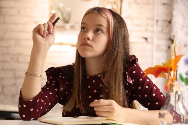 Genç ve güzel bir kız oturmuş düşünüyor.