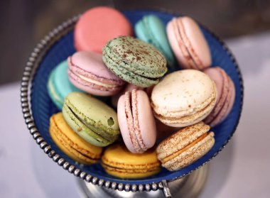 Ahşap bir masada renkli badem kurabiyeleri