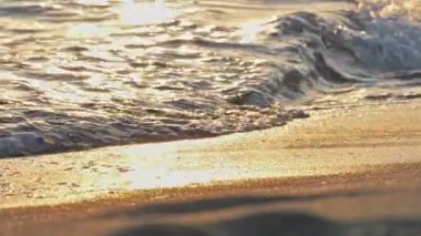 Sahil dalgası günbatımında makro su sıçratıyor.