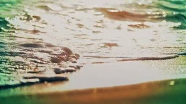 Sahil dalgası günbatımında makro su sıçratıyor.