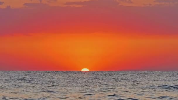 Grande sole giù sopra il mare, cielo rosso al rallentatore 4k — Video Stock